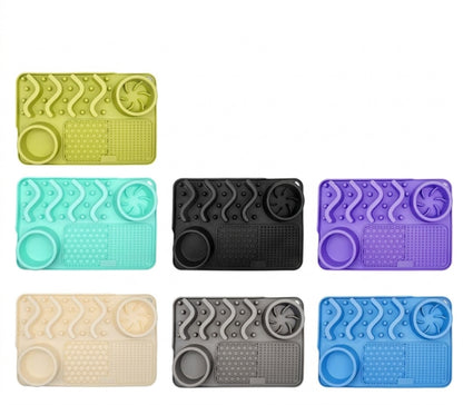 Photo montrant toutes les couleurs de disponibles du tapis de léchage en silicone. Vert, Bleu ciel, noir, violet, crème, gris et bleu.